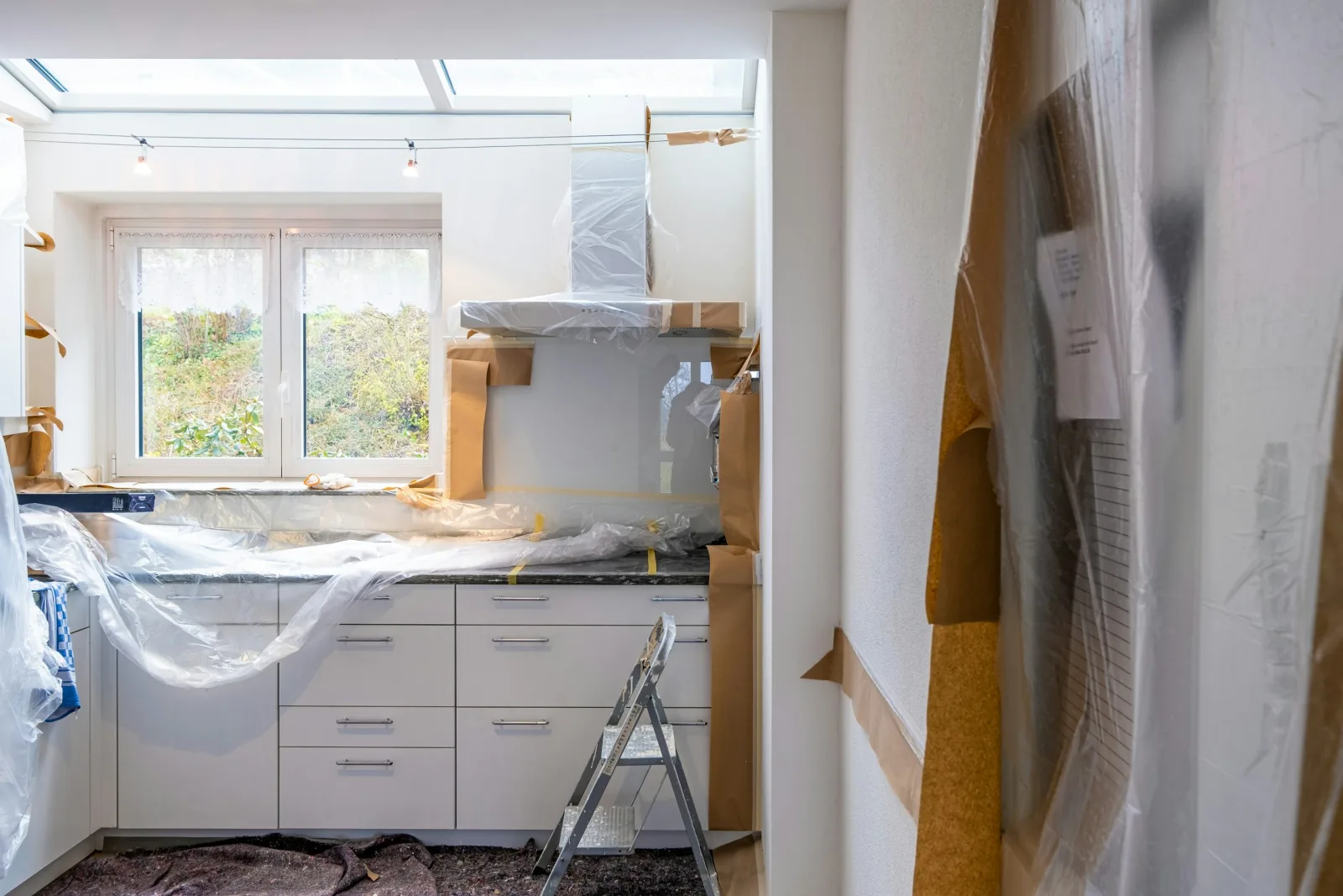 Kitchen counters and fixtures covered with protective plastic and paper during renovation